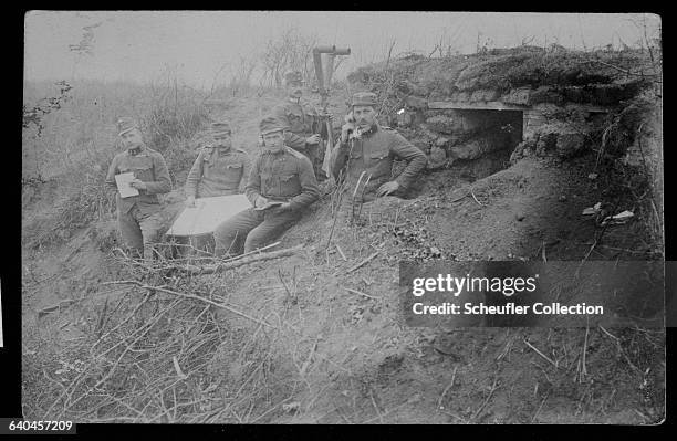 Group of Austrian soldiers in a First World War trench. One of the soldiers holds a field telephone.