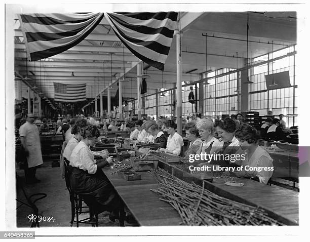 Workers at the Patent Fire Arms Plant in harford, Connecticut, inspect components of Colt .45 automatic pistols.