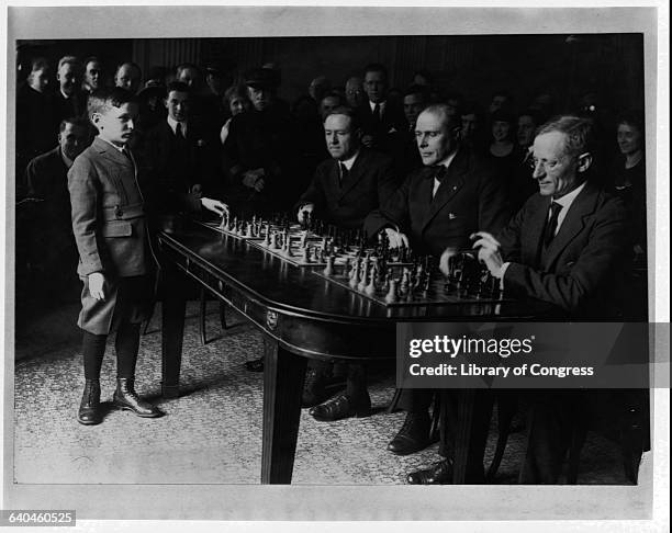 Samuel Rzeschewski, 10 year old international chess marvel, playing chess with Congressmen Meyer London, Roy Fitzgerald and James W. Collier, as an...