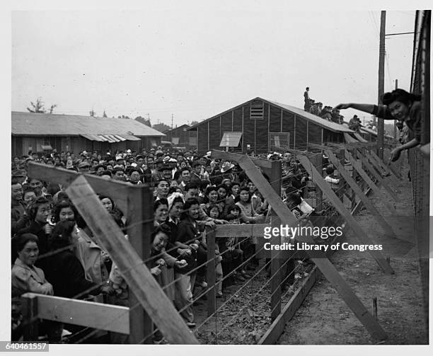 Japanese-American internees wave to friends departing by train from the Santa Anita Assembly Center at Santa Anita Racetrack in Arcadia, California,...
