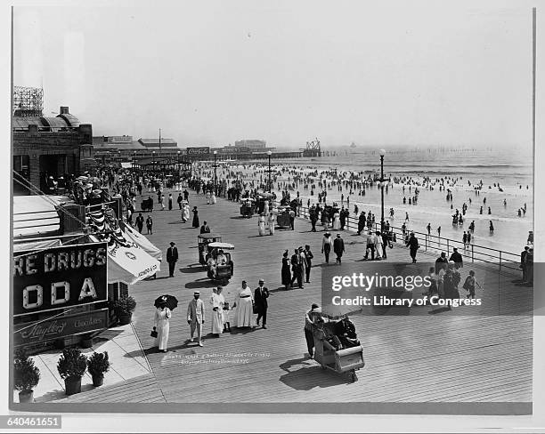 Families Strolling Past Storefronts on Atlantic City Boardwalk