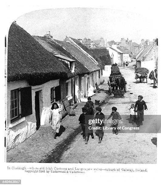 Several children walk down a street in Claddagh, a suburb of Galway, Ireland, ca. 1901.