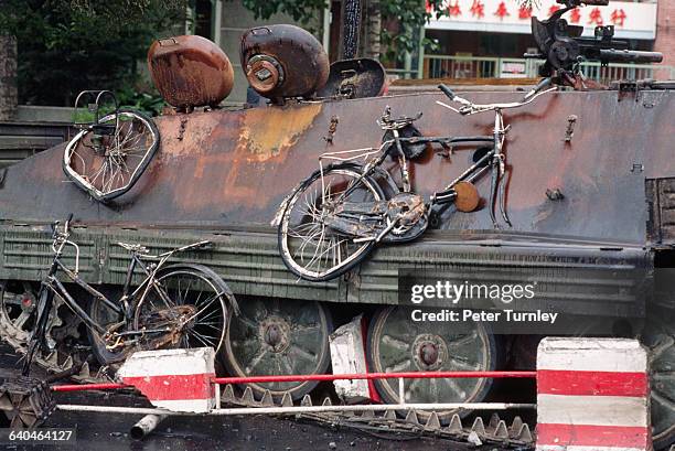 Mangled bicycles hang off the side of a PLA tank, which was burned by student protesters in Tiananmen Square, June 1989.