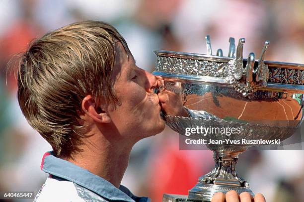 Yevgeni Kafelnikov kisses the trophy after winning the men's final of the 1996 French Open.