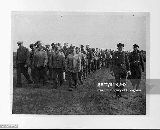 Two SS guards march a crowd of prisoners at a concentration camp at Emsland, Germany. 1935. | Location: Emsland, Germany.