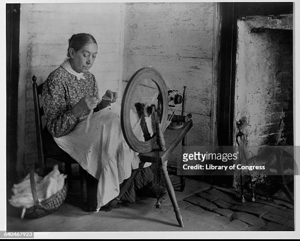 Elderly Woman Spinning by Fireplace