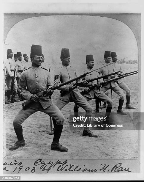 Egyptian soldiers wearing fezzes with their military uniforms practice a bayonet drill. Cairo, Egypt.