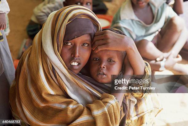 Mother and her child at an International Committee of the Red Cross famine relief and refugee camp during Somalia's civil war. In the 1980s warlord...