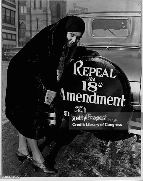 Elizabeth Thompson, a member of The Crusaders, puts a tire cover on her car that demands the repeal of the 18th amendment and the end of Prohibition...
