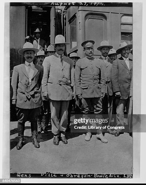 Pancho Villa, a Mexican revolutionary who became Governor of the State of Chihuahua in 1913, stands with Alvaro Obregon a soldier and a statesman who...