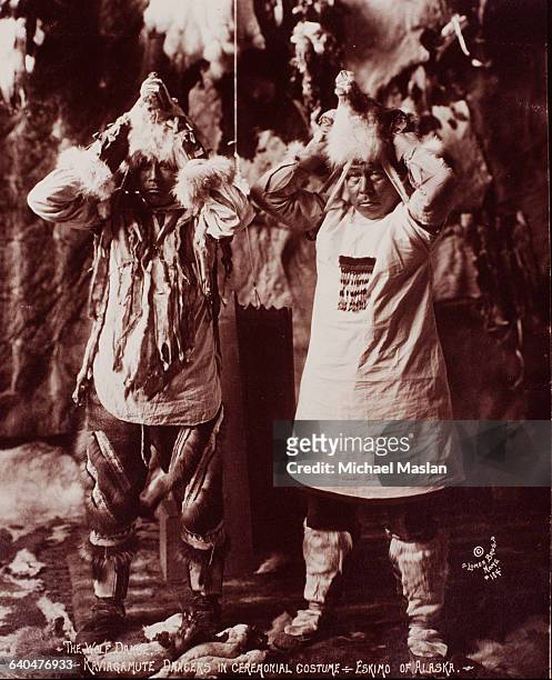 Two male dancers put on wolf heads prior to performing a ceremonial dance.