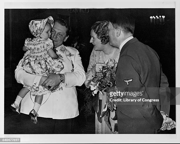 Adolph Hitler at Hermann Goering's birthday party, with Goering's wife Emmy and baby daughter Edda.