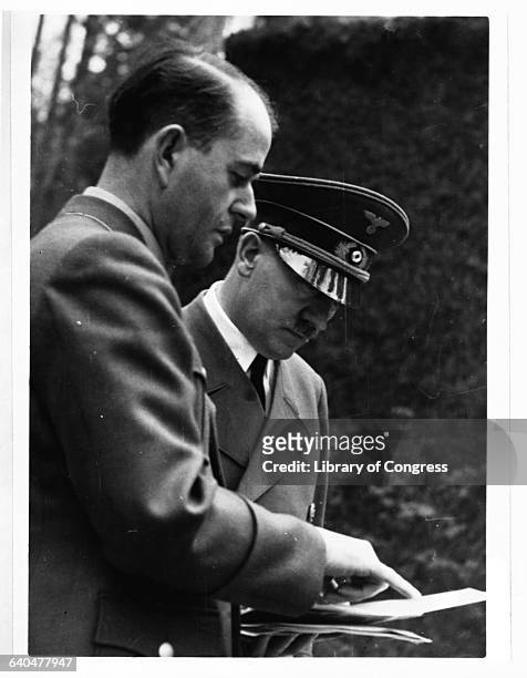 At FHQ Wolfsschanze, Adolf Hitler looks over some papers with architect and armaments minister Albert Speer.