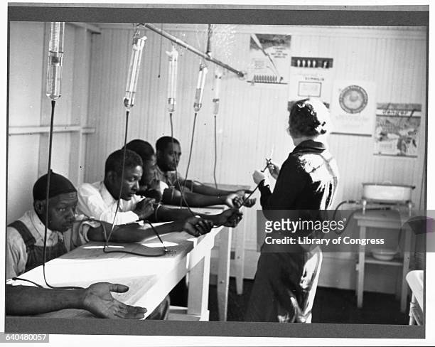 Nurse gives African American men intravenous treatment for venereal disease at a clinic in Georgia.