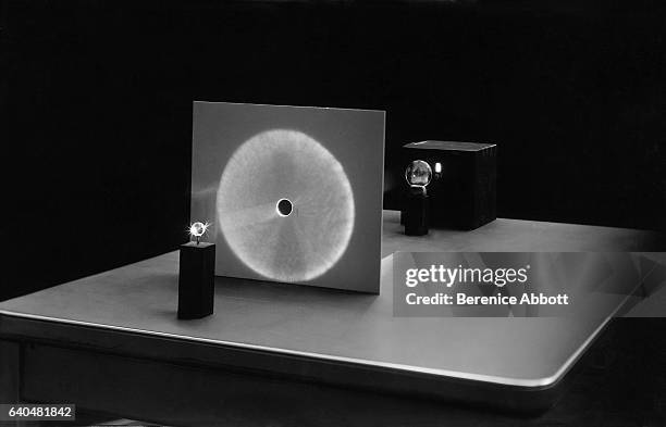 View of an apparatus setup to show rainbows, Massachusetts, late 1950s. It features, from left, a refracting sphere, a screen, a focusing lens, and a...