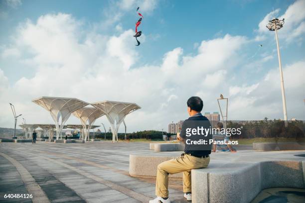 man fly a kite - fuzhou stock-fotos und bilder
