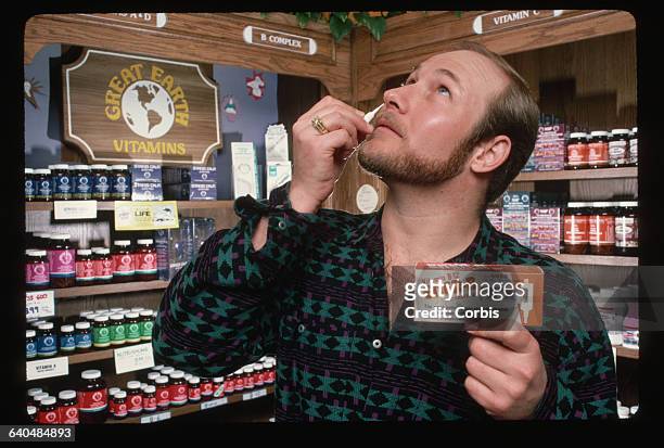 Rexford Hitchcock, owner of the Great Earth vitamin store in San Francisco, demonstrates how vitamin B-12 can be taken through the nose. A gel form...