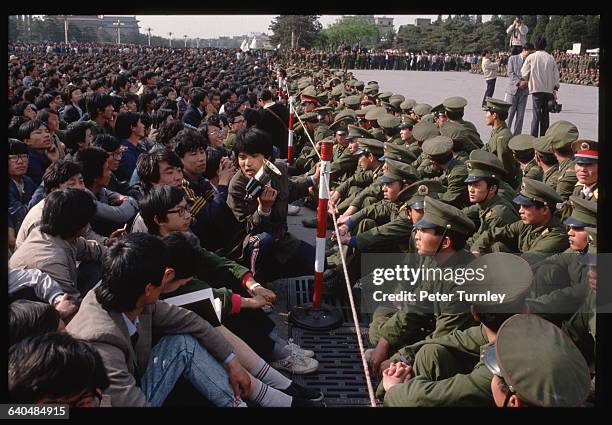 Soldiers keep student demonstrators away from the official memorial for Hu Yaobang at the Great Hall of the People, where the service is being held....