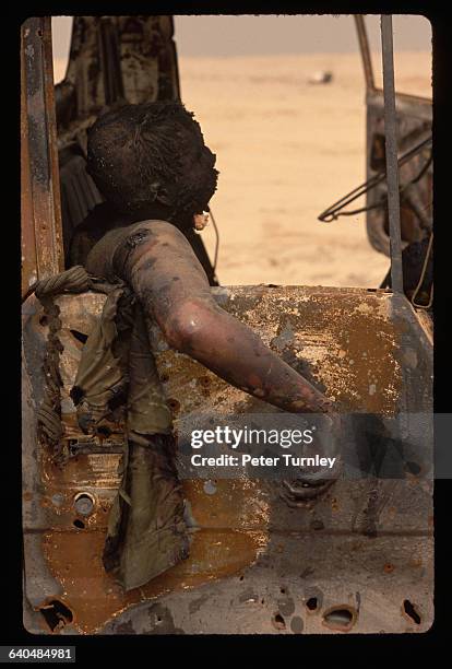 The burned corpse of an Iraqi soldier sits inside a burned truck.