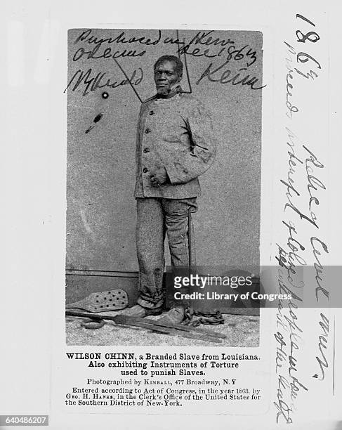 Wilson Chinn, a branded slave from Lousiana, exhibits torture implements used to punish slaves, ca. 1863.