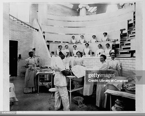 Doctor and nurses prepare a patient for an operation in an auditorium at Saint Lukes Hospital, New York City, 1899. | Location: Saint Lukes Hospital,...