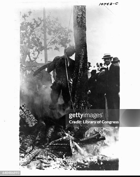 Onlookers crowd around the charred corpse of lynching victim Jesse ...