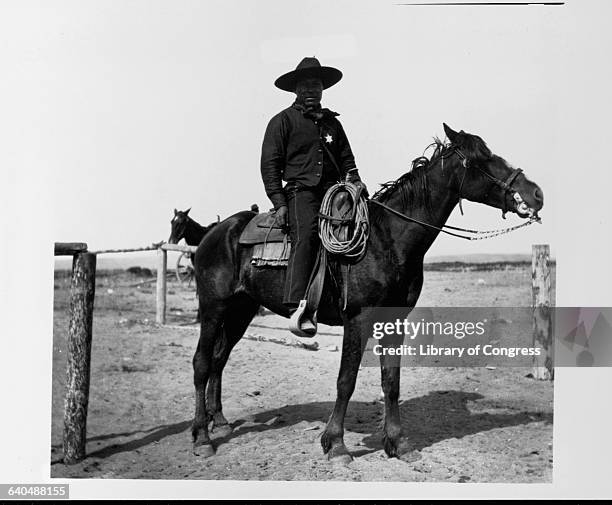 An African American cowboy sits saddled on his horse in Pocatello. At the crossing of the Oregon Short Line and the Utah and Northern railroads,...