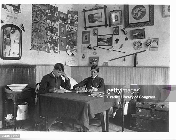 Two young North American Indians study at a table in their dormitory room at the Carlisle Indian School, Carlisle, Pennsylvania. | Location: Carlisle...