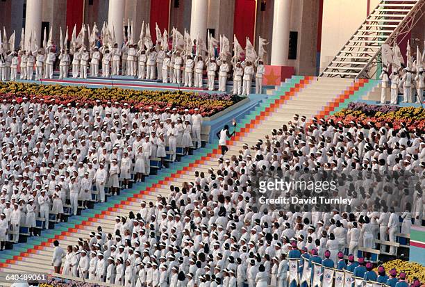 Torchbearer ascends a long stairway carrying a torch to light the Olympic flame at the opening ceremony. Many communist nations boycotted the Games...