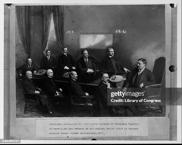 President Theodore Roosevelt sits at the head of the table with his cabinet members. Clockwise, from Roosevelt are, George B. Cortelyou, Secretary of...