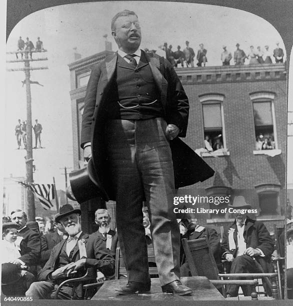 People gather round on roof tops and even telegraph poles to hear President Theodore Roosevelt speak in Hannibal, Missouri in 1903.