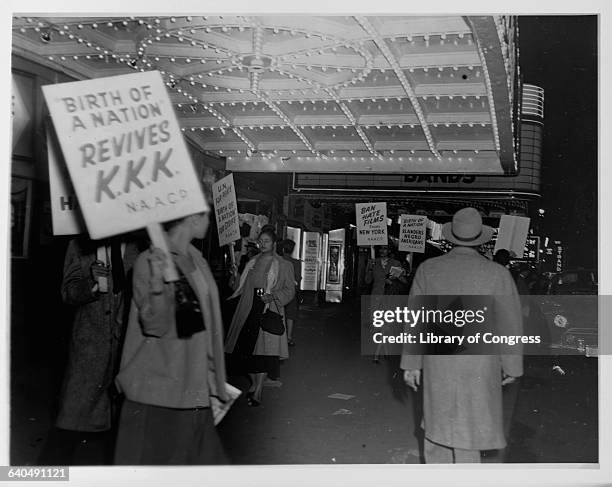 Members of the National Association for the Advancement of Colored People picket under the marquee of the Republic Movie Theatre against race...