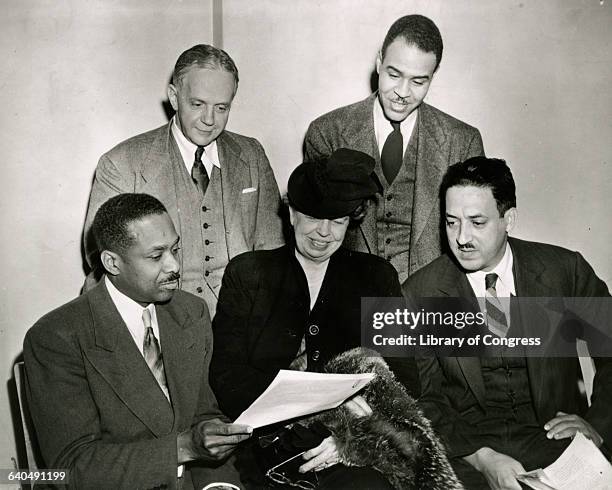 Eleanor Roosevelt and Dr. James McClendon, board members of the NAACP, go over the 1947 program with NAACP executive officers Walter White and Roy...