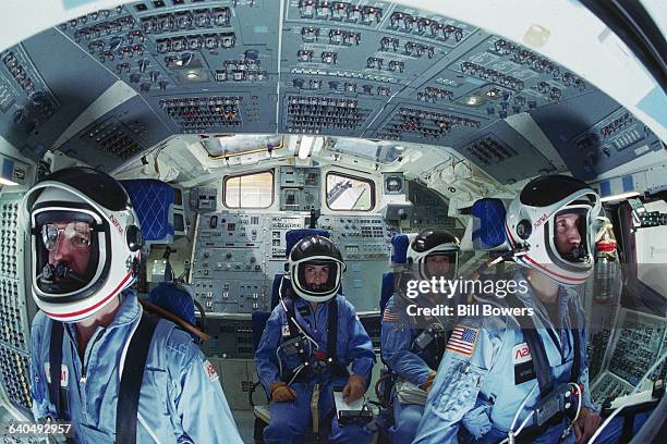 Four of the astronauts selected for the Space Shuttle Challenger mission in 1986 sit in the shuttle mission simulator . From left they are, Michael...