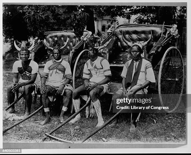 Rickshaw drivers wear headdresses and horns on their heads as they sit on their rickshaws.