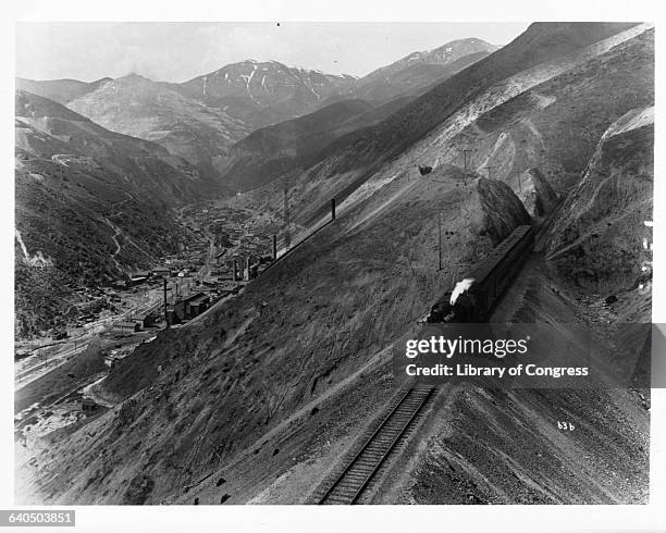 Steam locomotive pulls a passenger train through Bingham Canyon in Utah. | Location: near Bingham, Utah, USA.