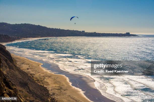 a hang glider rides the wind over black's beach in la jolla, california looking south towards the cove. - la jolla stock-fotos und bilder