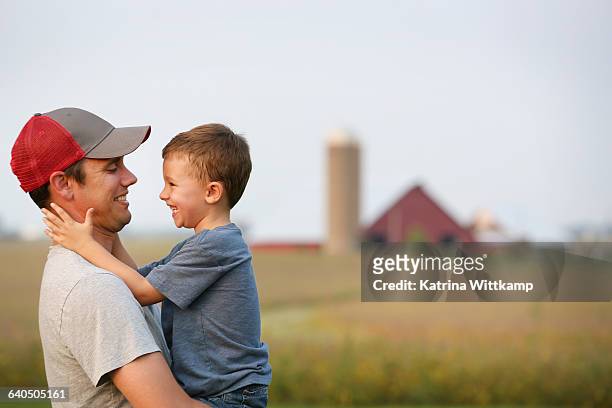 father and son on their family farm - fattoria foto e immagini stock