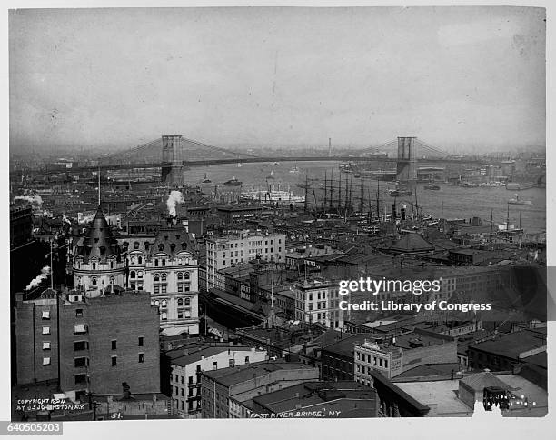 View of the Brooklyn Bridge from a neighborhood in the Lower East Side of Manhattan. The Brooklyn Bridge was the largest suspension bridge at the...