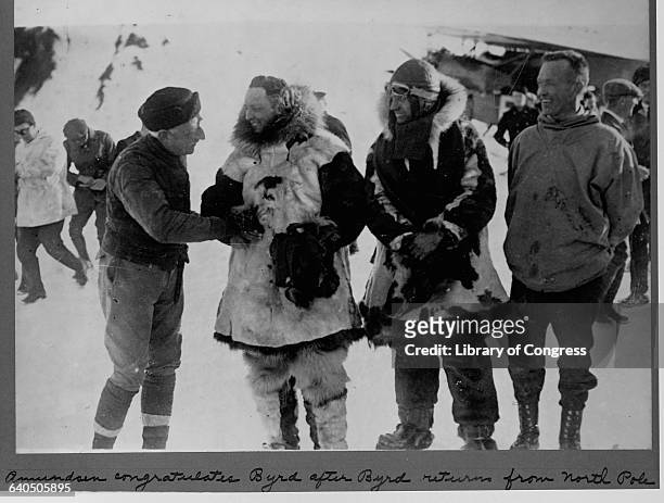 Roald Amundsen, the first explorer to reach the South Pole, meets Richard E. Byrd at Spitsbergen, Norway, to offer congratulations after Byrd's...