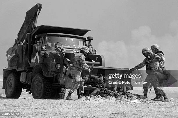 Military graves detail with a bulldozer buries the bodies of dead Iraqi soldiers killed along the Mile of Death in a mass grave Many of the Iraqi...