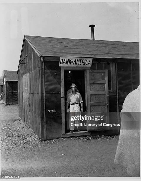 Japanese man walks out of the Bank of America in the Tule Lake Internment Camp, Newell, California, May 1943.