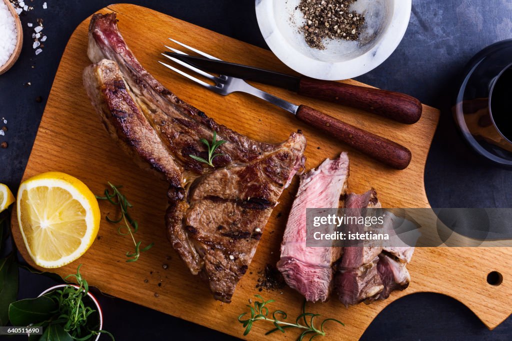 Barbecue bone-in ribeye steak on cutting board ready to eat, top view