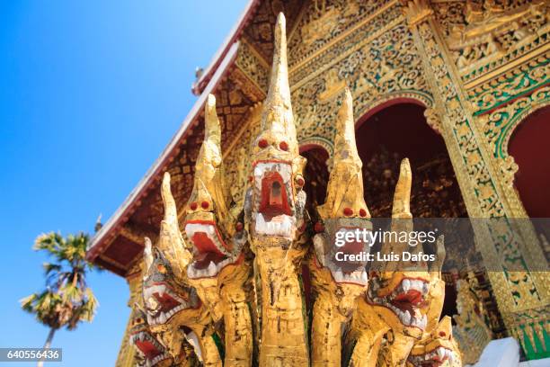 protective naga sculptures at a temple in luang prabang - wat imagens e fotografias de stock