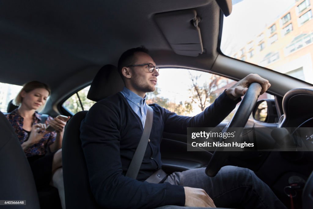Man driving with woman sitting in car