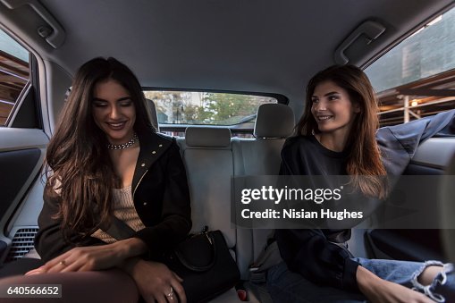 Two woman sitting in back of car together Two woman sitting in back of car together