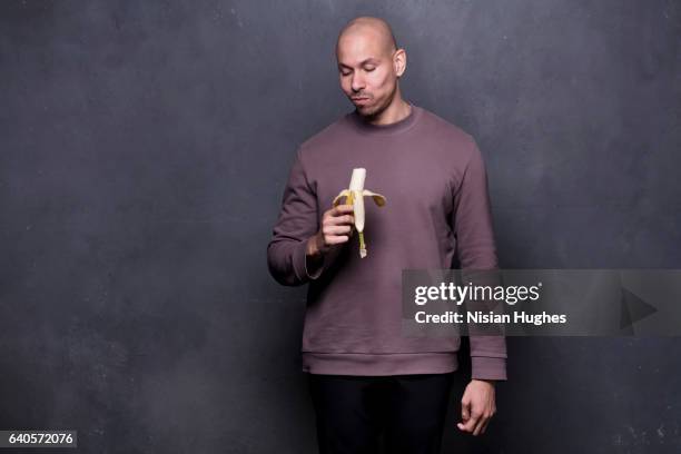 portrait of young man eating banana - long sleeve t shirt stock pictures, royalty-free photos & images