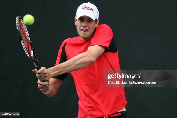 John Isner of the University of Georgia returns serve against Kevin Anderson and Ryan Rowe of the University of Illinois during the Division I Men's...