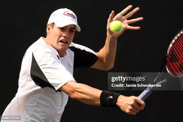 John Isner of the University of Georgia returns serve against Kevin Anderson of the University of Illinois during the Division I Men's Tennis...