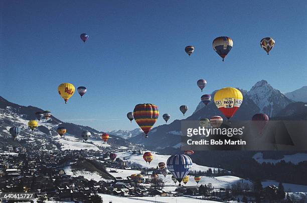 Hot air balloons rise over snow capped mountains in Gstaad for a balloon festival, the Gstaad International Balloon Fiesta on 1 January 1991 near...
